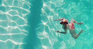 Аманда Сайфред плавает с голыми сиськами в бассейне